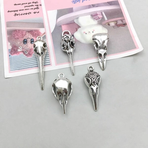 Macro detail of five antique silver bird skull pendants for DIY gothic jewelry making