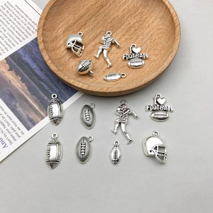 Détail de charms de football américain en argent antique avec pendentifs casque et ballon