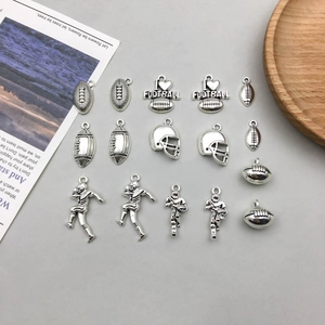 Vue détaillée des pendentifs de rugby en argent antique et breloques de casque de foot