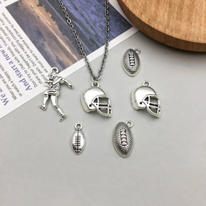 Détails des pendentifs de rugby en argent antique et casque de football sur fond gris