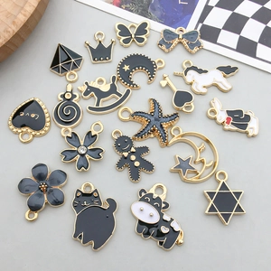 Close-up of black and white enamel animal charms in various shapes for DIY jewelry making