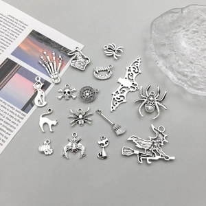 Macro detail of various antique silver Halloween charms like skulls, bats and pumpkins
