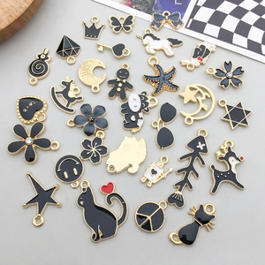Flat lay of assorted black enamel alloy charms with gold borders for DIY jewelry making