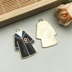 Macro view of graduation gown alloy charm with black drip oil finish for DIY jewelry
