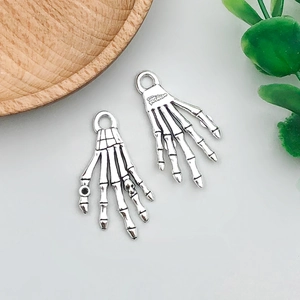 Macro detail van antieke zilveren skelet hand hangers voor Halloween DIY sieraden maken