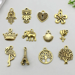 Collection of 12 antique gold alloy charms including Fatima hand, owl, and tree motifs