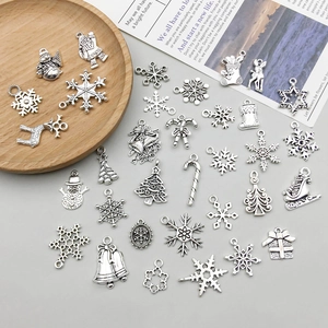 Close-up of antique silver Christmas charms including snowflakes and reindeer for DIY jewelry