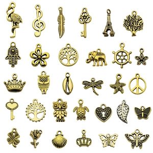 Collection of 30 vintage antique gold alloy charms including butterfly and tree leaf shapes