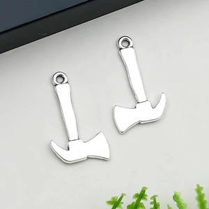 Détail de deux pendentifs haches miniatures en argent avec finition métal polie