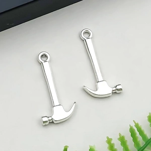 Détail de deux breloques marteaux en argent antique pour la création de bijoux DIY