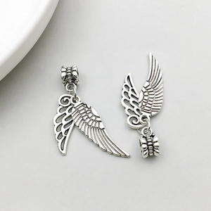 Macro view of vintage silver alloy wing charms with detailed feather texture for DIY jewelry