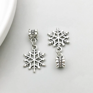 Detailed macro view of silver alloy snowflake charms with engraved large hole bail beads