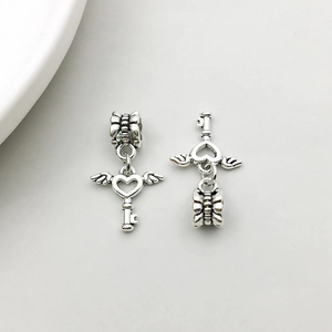 Detail of vintage silver heart key pendants with wings for DIY jewelry making