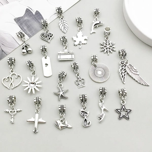 Macro shot of 20 vintage silver alloy pendants including maple leaf and heart shapes