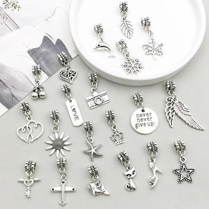 Detailed flat lay of assorted antique silver alloy charms including maple leaf and heels