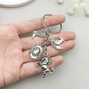 Antique silver cowboy keychain with horse, hat, and boot charms held in hand