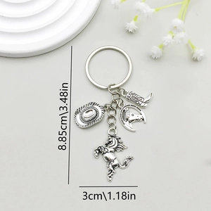 Antique silver cowboy hat and horse charms keychain accessory on minimalist background