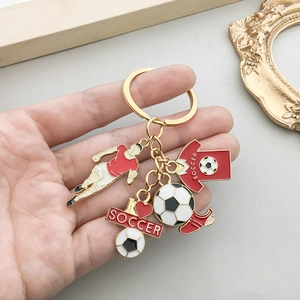 Goldener Fußball-Schlüsselanhänger mit rotem Trikot und Sportler-Anhängern