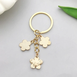 Vue détaillée du porte-clés fleur dorée avec des pétales texturés sur fond clair