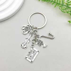 Detail of vintage silver music charms including saxophone, violin and retro cassette tape