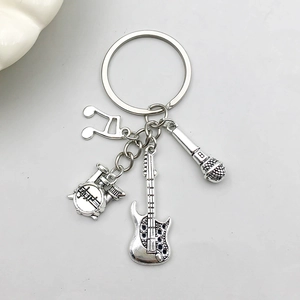 Detail of silver music keychain with mini guitar, drum kit, microphone and musical note