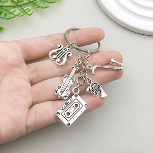 Vintage silver music keychain with saxophone, cello and cassette tape charms