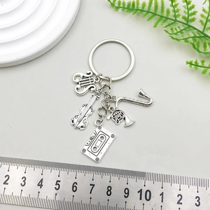 Antique silver music-themed keychain featuring violin, saxophone, and cassette charms