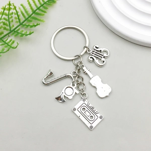 Detailed macro view of silver alloy saxophone and vintage tape music keychain charms
