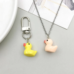 Close-up of yellow resin duck keychain and pink duck pendant necklace DIY jewelry parts