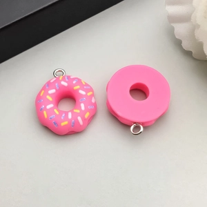 Macro-opname van kleurrijke hars donut bedeltjes met hagelslag en haken voor DIY sieraden