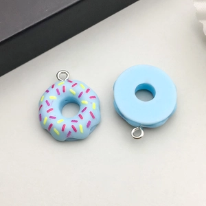 Detail van lichtblauwe hars donut hangers met gekleurde hagelslag en zilveren ringen