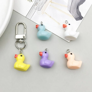 Close-up of colorful resin duck pendants in five colors with metal loops for DIY jewelry