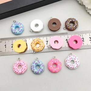 Detailweergave van 2cm kleurrijke donutbedeltjes van hars met zilveren ringen en schaal