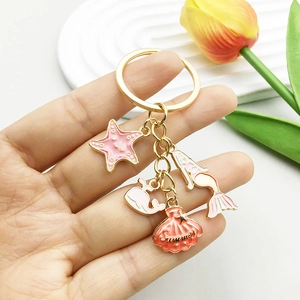 Golden keychain featuring pink mermaid, whale, and shell charms with Summer engraving