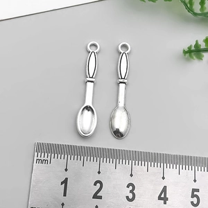 Detailed view of vintage silver alloy spoon pendants with length scale for DIY jewelry