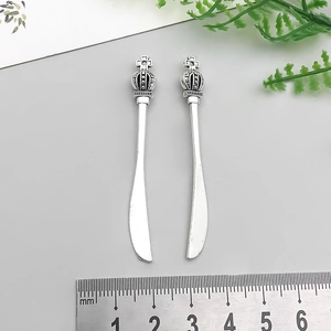Detail of antique silver alloy knife charms with vintage crown handles and 55mm ruler scale