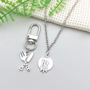 Close-up of vintage silver alloy cutlery pendants with fork and knife design for jewelry DIY