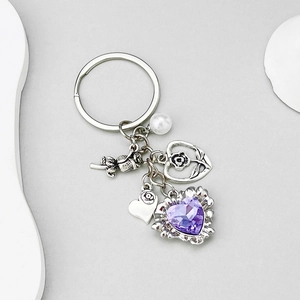 Détail du porte-clés rose avec cristal de cœur violet et breloques en argent