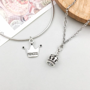 Detailansicht von Silberhalskette und Armband mit Kronenanhänger und Princess-Gravur