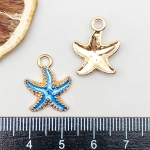 Macro detail of blue starfish pendants showing gradient enamel texture and gold back