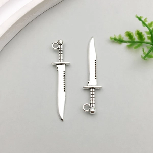 Macro detail of antique silver alloy dagger pendants for DIY jewelry making