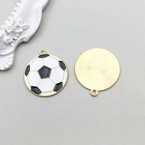 Detail of soccer ball charms with black and white enamel front and golden sunburst back side