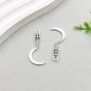 Detail of vintage silver sickle charms with ornate engraved handles for DIY jewelry