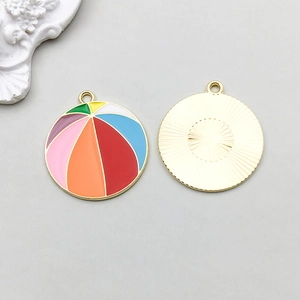 Macro detail of colorful beach ball enamel pendants with radial sunburst metal texture