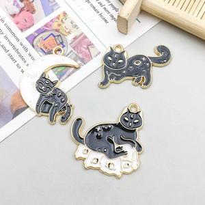 Three Halloween black cat enamel charms with celestial patterns and gold metal borders