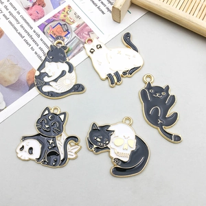 Detailed set of five black and white enamel cat pendants with gothic gold outlines