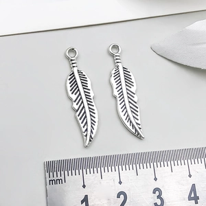 Detailaufnahme der Blattsilberanhänger mit Federstruktur und Maßstab für DIY-Schmuck