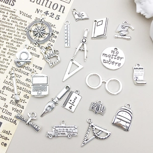 Vue détaillée de breloques en argent antique sur le thème de la remise des diplômes