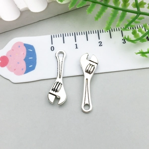Détail de breloques clé en argent pour bijoux DIY présentées sur une règle graduée