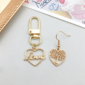 Dettaglio di portachiavi a cuore dorato con incisione Love e orecchino a cuore